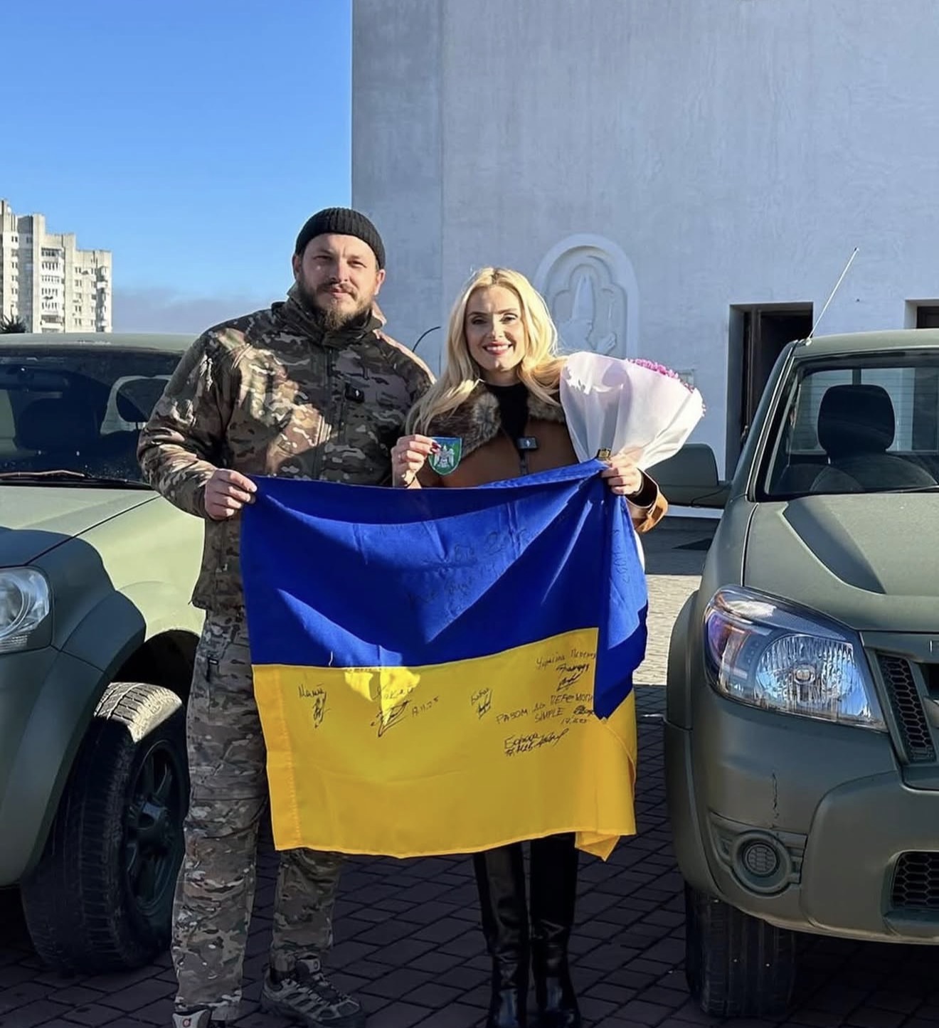 Signed Ukrainian flag between two delivered trucks